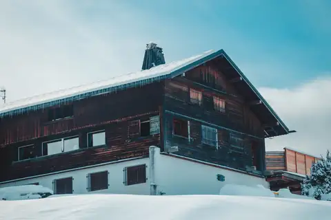 Wooden alpine chalet blanketed in deep snow